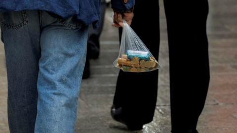 un hombre lleva una bolsa con monedas, en Ronda (Málaga). REUTERS/Jon Nazca