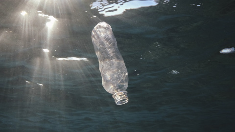 Imagen de una botella de plástico en el mar.