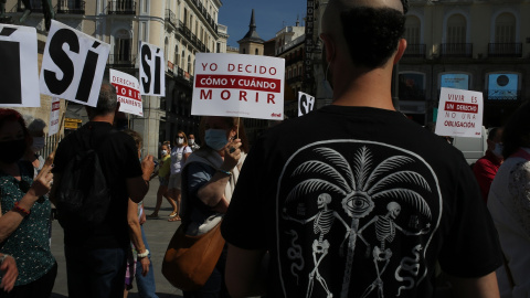 Un grupo de personas se reúne sosteniendo pancartas y carteles durante la concentración de la asociación Derecho a Morir Dignamente (DMD) en la Puerta del Sol