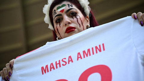 30/11/22 Una aficionada iraní sostiene una camiseta de fútbol con el nombre de Mahsa Amini como protesta durante un partido del Mundial de Catar