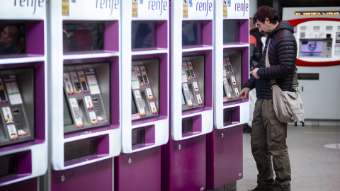 Un hombre en las máquinas auto-venta de Renfe, en la estación Puerta de Atocha-Almudena Grandes con motivo del inicio del Puente de la Constitución, a 2 de diciembre de 2022, en Madrid.