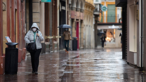 Transeúntes por la calle Sagasta durante una jornada de lluvia. En Sevilla (Andalucía, España), a 22 de octubre de 2020.