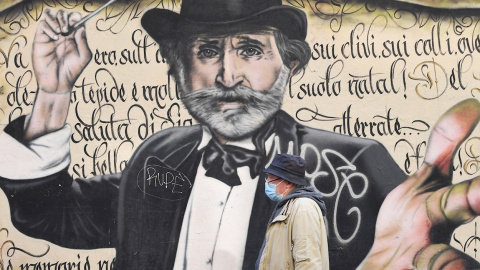 Un hombre pasa frente a un mural en Milán, Italia