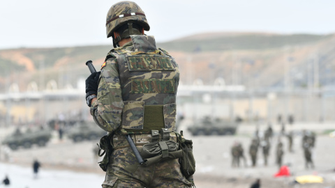 Un militar del ejército español vigila durante las devoluciones en caliente que están efectuando a los migrantes que han entrado en Ceuta procedente de Marruecos, a 18 de mayo de 2021, en Ceuta, (España).