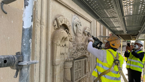 Unos operarios eliminan del edificio del antiguo Palacio de Justicia de Vitoria el último escudo de la época franquista que quedaba visible en las calles de la ciudad.