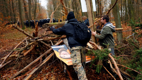 Los manifestantes levantan una barricada de madera después de que los oficiales de policía la desmantelaron durante una protesta contra la extensión de la autopista A49, en un bosque cerca de Stadtallendorf, Alemania.