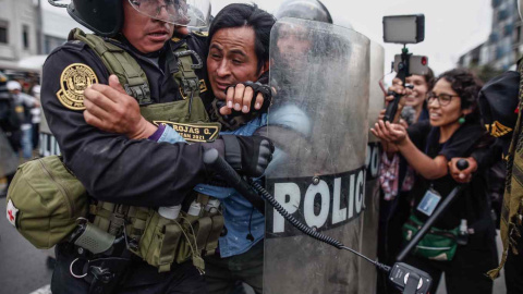 Manifestantes que respaldan al destituido presidente Pedro Castillo enfrentan a la Policía, a las afueras de la Prefectura de Lima, donde permanece detenido el ahora expresidente, hoy, en Lima (Perú).