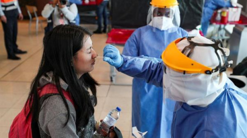 Personal médico realiza pruebas PCR en un aeropuerto