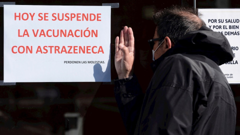 Un hombre trata de ver a través del cristal de un centro de vacunación en Valladolid este miércoles tras el anuncio de la Comunidad de suspender cautelarmente la vacunación contra la covid con viales de AstraZeneca hasta conocer el informe de segurida