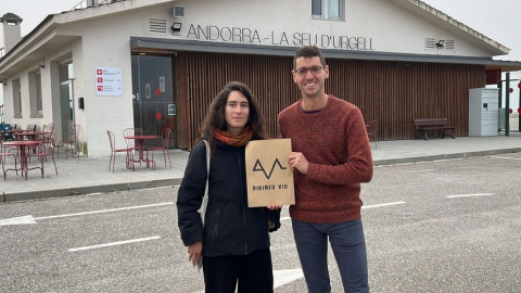 Dos portaveus de la nova plataforma amb el cartell de l'organització a l'exterior de la terminal de l'aeroport d'Andorra - La Seu d'Urgell