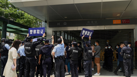 Agentes de la policía tratan de disolver la concentración de inversores y proveedores de la inmobiliaria China Evergrande, frente a su sede en la ciudad de Shenzhen, al sudeste del país, ante el temor de la que la empresa vaya a la quiebra y no les pag