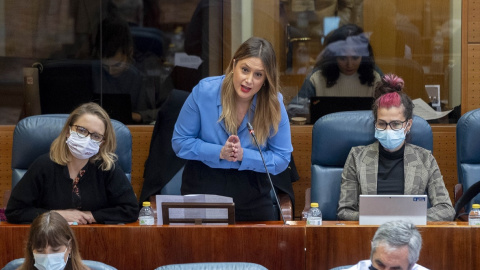 Carolina Alonso, Alejandra Jacinto (de pie) y Vanesa Lillo, portavozas de Unidas Podemos en la Asamblea de Madrid