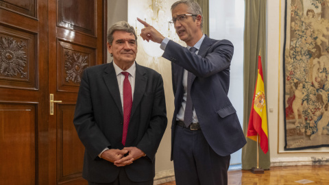 El exgobernador del Banco de España, Pablo Hernández de Cos (d), habla con su sucesor José Luis Escrivá, durante el acto de posesión de este último como nuevo responsable de la institución. EFE/ Borja Sánchez-Trillo