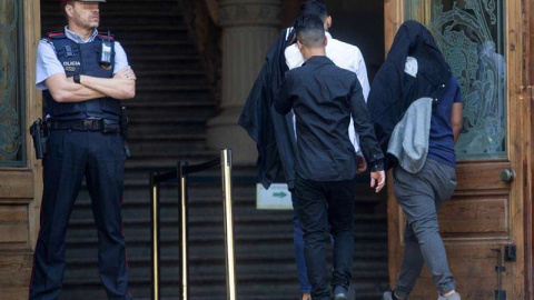 Tres de los siete acusados de la violación múltiple de una menor en Manresa (Barcelona), entrando en la Audiencia de Barcelona. (QUIQUE GARCÍA | EFE)