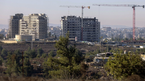 Nuevos edificios de apartamentos en construcción en el asentamiento de Beit El en la ocupada Cisjordania con la ciudad palestina de Ramallah al fondo.