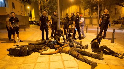 Agentes de Policía junto a un grupo de inmigrantes que logró llegar a Ceuta cruzando a la carrera por el paso de El Tarajal.- REUTERS JESÚS MORON/ ARCHIVO