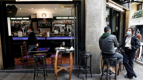 Dos personas toman un aperitivo en el exterior de un bar del Casco Viejo de Pamplona. — Jesús Diges / EFE