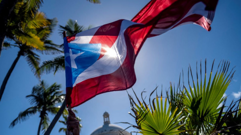 Imagen de archivo de una bandera puertorriqueña frente al edificio del Capitolio durante una protesta de maestros que exigen mejoras salariales, en San Juan, Puerto Rico, el 9 de febrero de 2022.