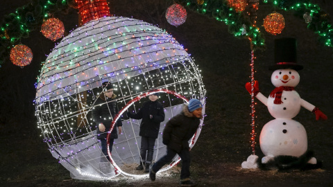 Varios niños juegan en un parque que está decorado con luces de navidad, en Kiev, Ucrania. REUTERS / Valentyn Ogirenko