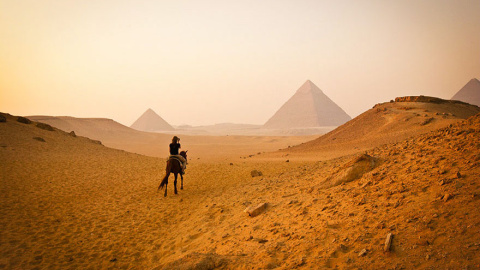 Una joven visita a caballo las pirámides de Giza, en Egipto /Architecture and Design