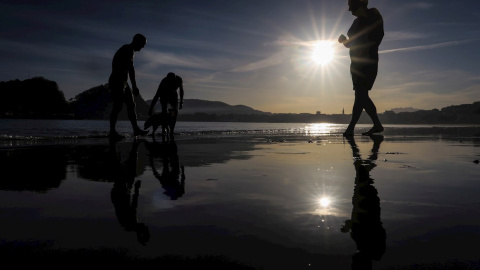 Varias personas pasean en la playa de Ondarreta de San Sebastián.