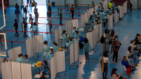 Cientos de docentes reciben la primera dosis de la vacuna AstraZeneca en un pabellón deportivo de la Universidad de Sevilla.