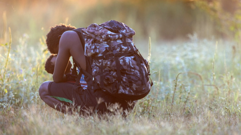 Un migrante haitiano exhausto lleva a su hijo en brazos en río Bravo (Texas).