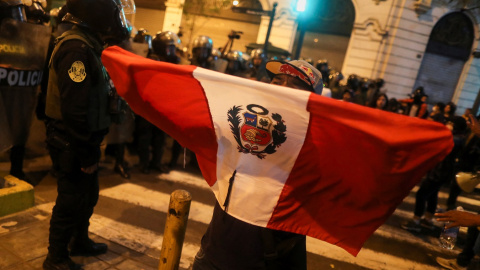 Un manifestante sostiene una bandera de Perú durante las protestas en Lima tras la proclamación del estado de emergencia, a raíz de la movilizaciones por la destitución del presidente Pedro Castillo. REUTERS/Sebastian Castaneda