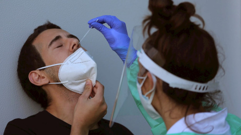 Personal sanitario realiza una prueba de PCR a un hombre, en una imagen de archivo.