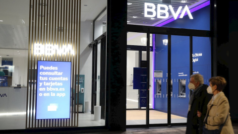 Una pareja pasa frente a una oficina del BBVA, en Bilbao. EFE/LUIS TEJIDO