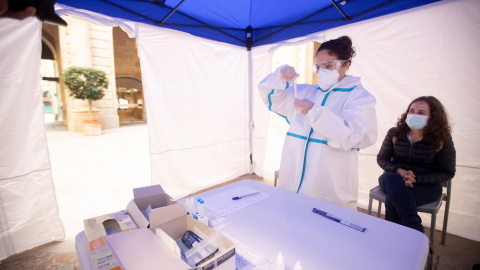 18/11/2020.- Una mujer se realiza una PCR en uno de los puntos habilitados por la Cambra de Comerç de Barcelona para realizar test rápidos de antígenos.