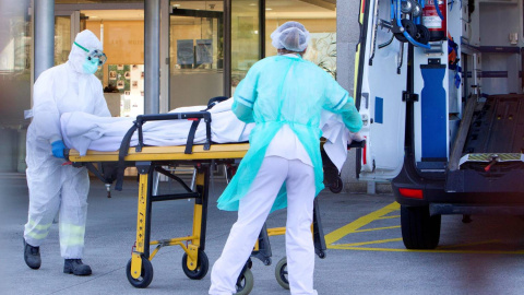 Dos sanitarios trasladan a un paciente de covid-19 en una camilla a un hospital.