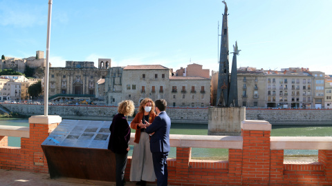 El vicepresident Pere Aragonès, la consellera de Justícia Ester Capella i l'alcaldessa de Tortosa,Meritxell Roigé, davant del monument franquista des del passeig de l'Ebre.