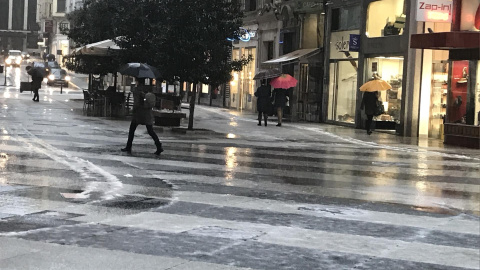 Jornada de lluvia y granizo en Santander, gente con paraguas, lluvia, frío./ EUROPA PRESS - Archivo