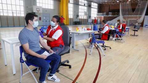 La Comunidad de Madrid comienza a vacunar contra el COVID-19 sin necesidad de cita previa en campus universitarios de la región. En la imagen, un joven recibe una dosis de la vacuna en el polideportivo de la Almudena de la Universidad Complutense (UCM), 