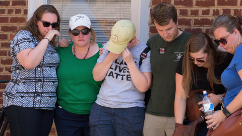 Varias personas muestran su dolor después de depositar unas flores en la esquina de la calle de Charlottesville donde se produjo el atropello por parte de un racista contra un grupo de manifestantes. EFE/EPA/TASOS KATOPODIS