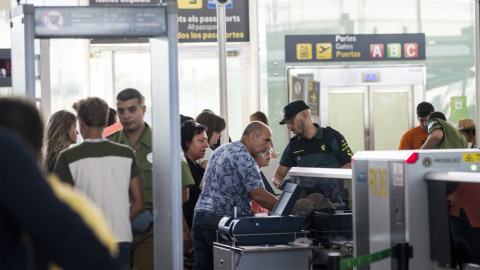 Efectivos de la Guardia Civil trabajan en los accesos a las puertas de embarque del aeropuerto de Barcelona-El Prat . EFE/Quique García