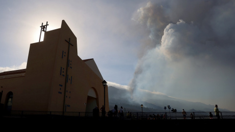 Imagen de una Iglesia en Los Llanos de Aridane. Al fondo, el volcán de La Palma en erupción.