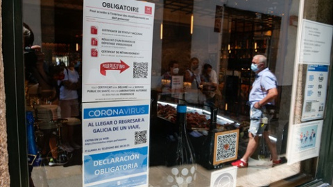 Carteles en diferentes idiomas de indicaciones de obligatoriedad de presentar certificados antes de acceder al interior, en una marisquería de la Rua do Franco, el día en que el TSXG declara nula la petición de certificado Covid para entrar en hosteler