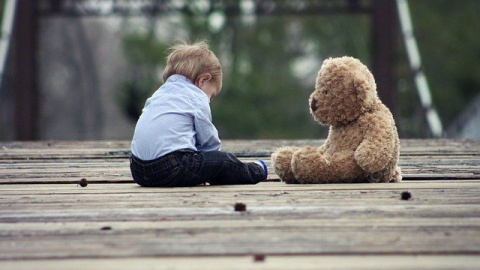 Foto de archivo de un niño con un oso de peluche.