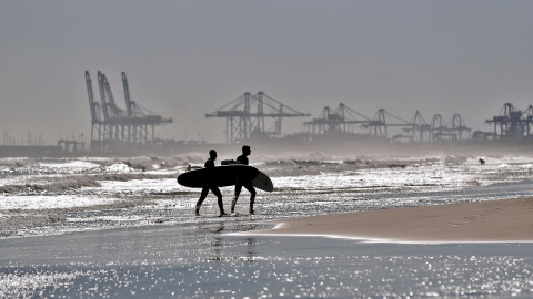 Dos surfistas salen de la playa de La Malvarrosa de València donde las olas y el cielo despejado han animado a numerosas practicantes de este deporte a acercarse al mar.