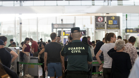 Un agente de la Guardia Civil en un control de seguridad del Aeropuerto de Barcelona-El Prat, donde se han vuelto a registrar colas de hasta una hora. EFE/Quique García