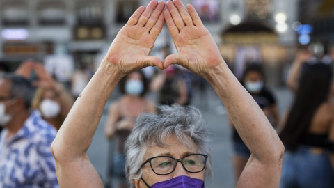 Una mujer levanta las manos en una concentración para exigir “El Pacto de Estado Contra la Violencia de Género”, a 6 de agosto de 2021, en la Puerta del Sol.