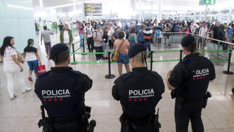 Agentes de los Mossos d'Esquadra controlan de los accesos a las puertas de embarque en el Aeropuerto de El Prat. .- Quique García (EFE)