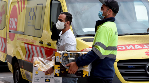 Dos voluntarios llevan al pabellón deportivo de Los Llanos de Aridane comida donada por empresa de La Palma para las familias desplazadas de sus viviendas por la erupción del volcán.