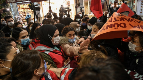 Manifestantes chocan con agentes de policía cuando intentan pasar la barricada para seguir marchando por la avenida Istiklal, la principal calle comercial de Estambul, durante una manifestación del 25N.