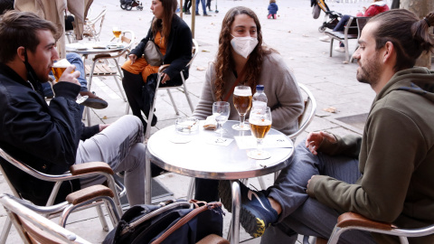 Unos joves prenent una cervesa tomando a la plaça de la Virreina (Barcelona).