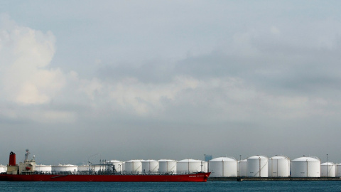 Un barco amarrado cerca de tanques de almacenamiento en una refinería de petróleo frente a la costa de Singapur. REUTERS/Vivek Prakash