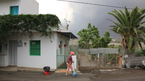 Katia barre la puerta de su casa en La Aldea de La Laguna, cerca de Todoque, y amontona cenizas que no paran de caer del cielo.