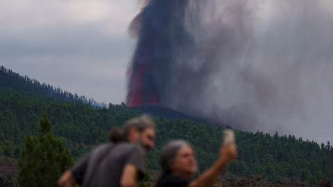 Varias personas observan la actividad de la erupción volcánica, este lunes por la tarde en La Palma, donde se esperan explosiones y gases nocivos al llegar la lava al mar.